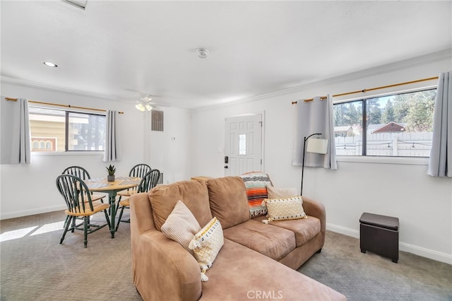 living room with a healthy amount of sunlight, crown molding, light carpet, and ceiling fan