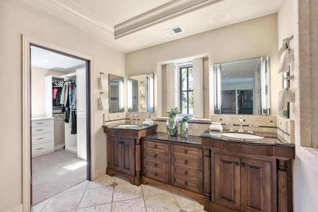 bathroom featuring tile patterned flooring, vanity, decorative backsplash, and crown molding