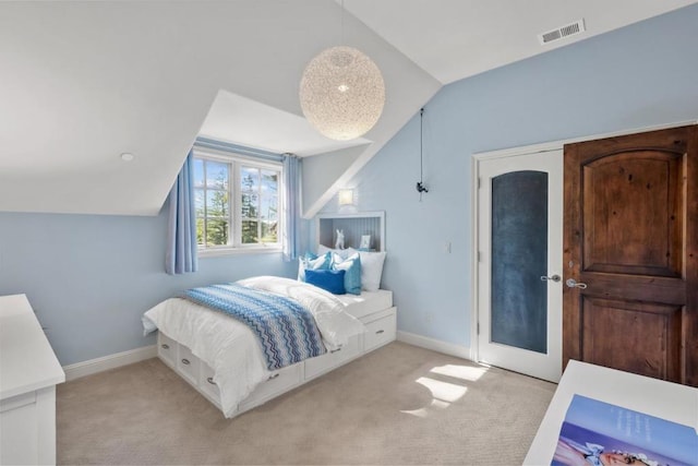 bedroom featuring lofted ceiling and light carpet