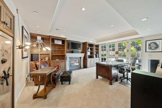 carpeted home office with a tray ceiling and french doors