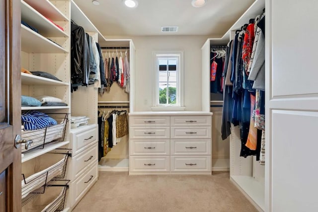 walk in closet featuring light carpet