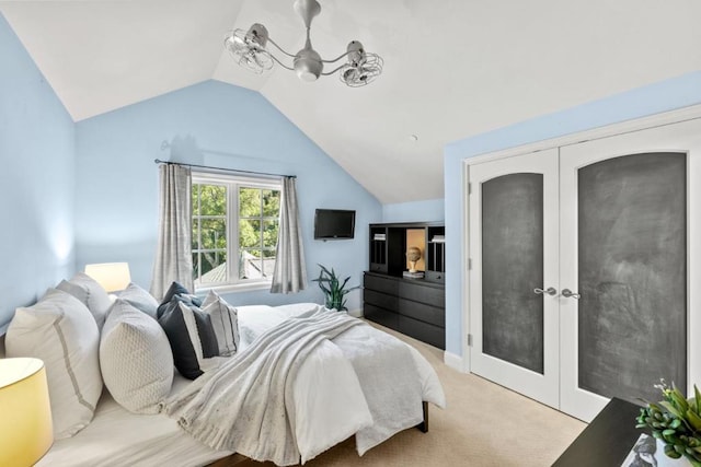 carpeted bedroom with a chandelier and vaulted ceiling