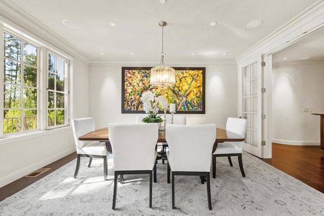 dining room featuring crown molding, a notable chandelier, and hardwood / wood-style flooring