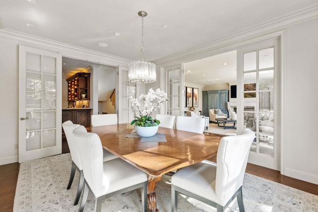 dining area featuring wood-type flooring, crown molding, and french doors