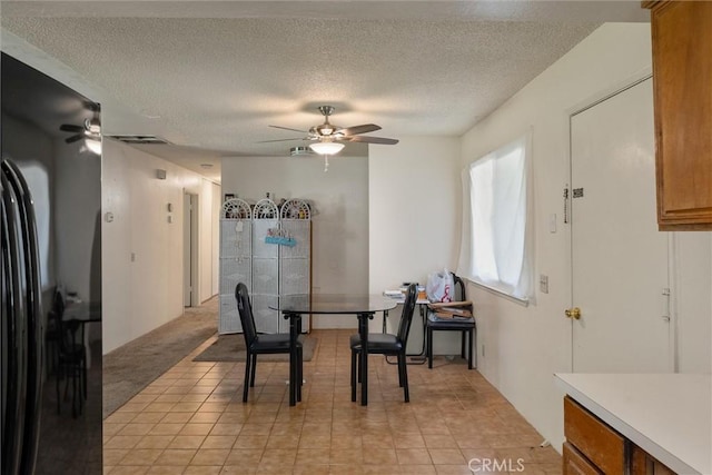 dining area featuring light carpet and a textured ceiling