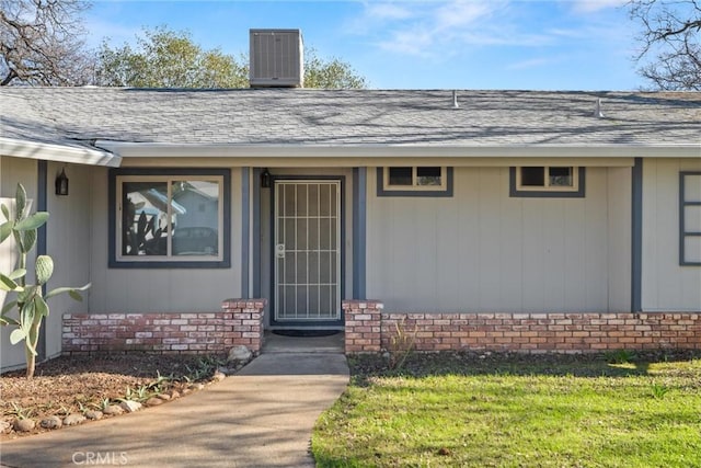 doorway to property featuring a yard and cooling unit