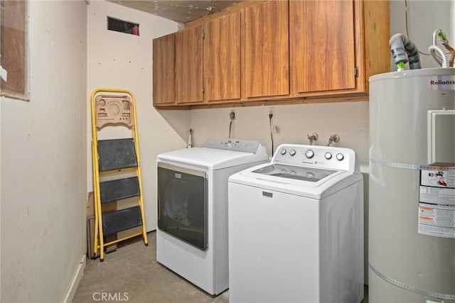 clothes washing area featuring electric water heater, washer and clothes dryer, and cabinets