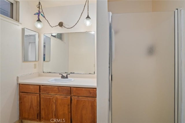 bathroom with vanity and a shower with door