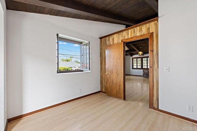 unfurnished room with wooden ceiling, vaulted ceiling with beams, baseboards, and wood finished floors