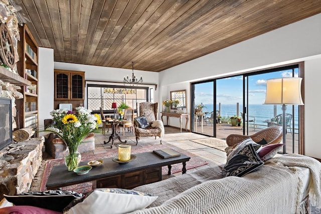 living area featuring a notable chandelier, a healthy amount of sunlight, wooden ceiling, and a water view