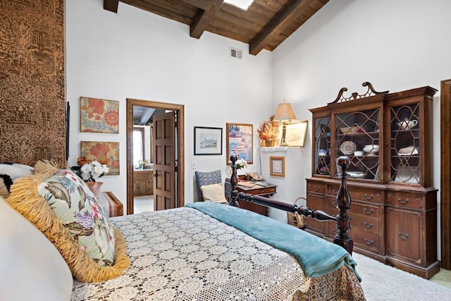 carpeted bedroom featuring visible vents, beam ceiling, wooden ceiling, ensuite bathroom, and high vaulted ceiling