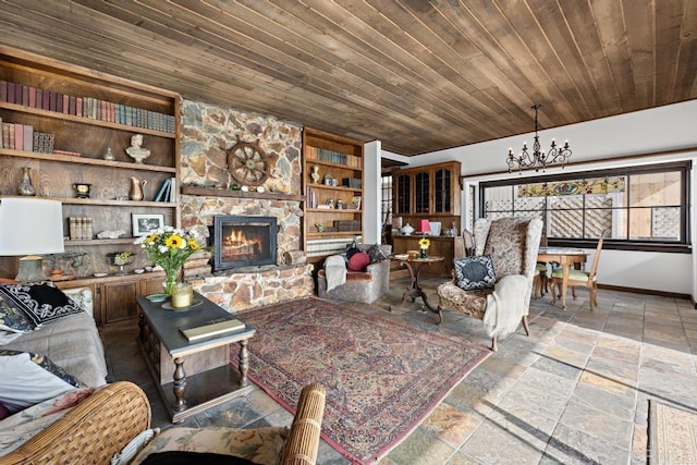 living room with built in features, stone tile flooring, a stone fireplace, wooden ceiling, and an inviting chandelier