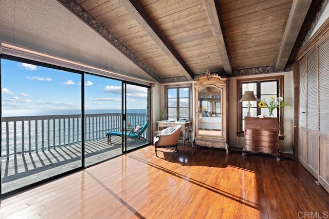 unfurnished sunroom featuring wooden ceiling, vaulted ceiling with beams, and a water view