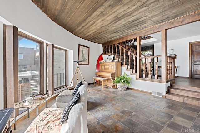 unfurnished living room featuring stairs, wooden ceiling, stone finish floor, and visible vents