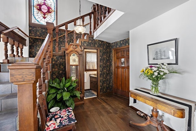 foyer featuring wallpapered walls, stairway, dark wood-style floors, and a high ceiling