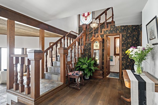 entryway with wood-type flooring, plenty of natural light, stairs, and wallpapered walls