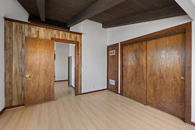 spare room featuring wood finished floors, visible vents, beam ceiling, baseboards, and wood ceiling