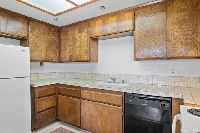kitchen featuring brown cabinetry, a sink, and white appliances