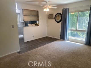 carpeted empty room with ceiling fan and a wall unit AC