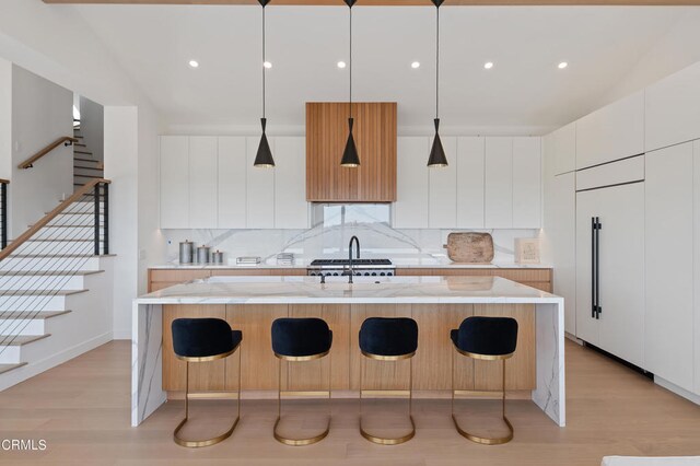 kitchen featuring a spacious island, light wood-type flooring, and white cabinetry