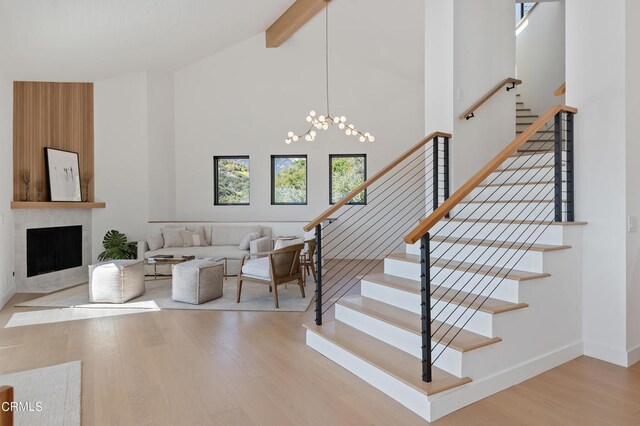 staircase featuring high vaulted ceiling, beam ceiling, hardwood / wood-style flooring, and an inviting chandelier