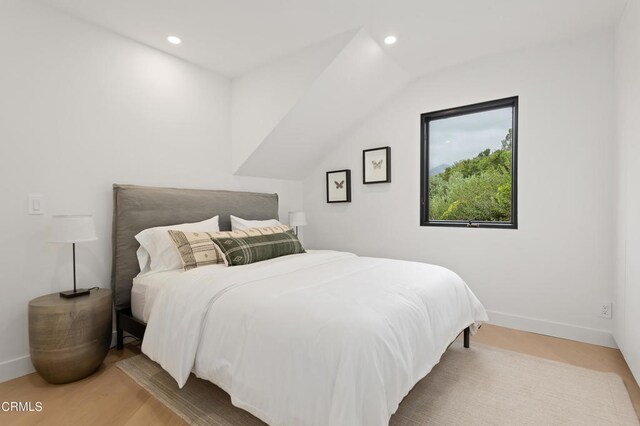 bedroom featuring vaulted ceiling and hardwood / wood-style floors