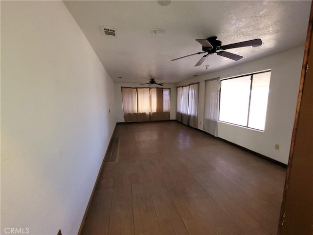 empty room with ceiling fan and wood-type flooring