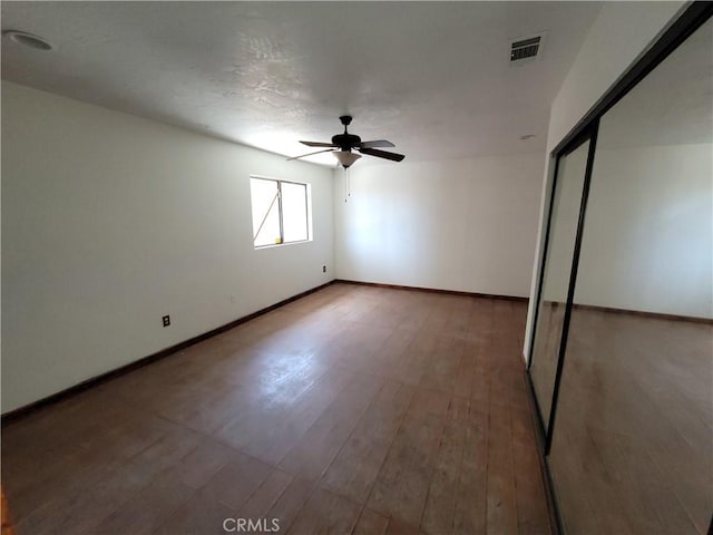 unfurnished bedroom with wood-type flooring, a closet, and ceiling fan