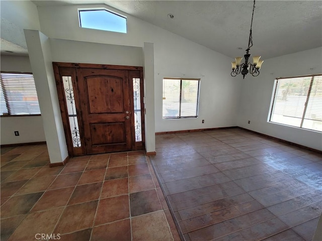 31801 Soapmine Rd, Barstow, CA 92311 - entrance foyer featuring lofted ceiling, a chandelier, healthy amount of natural light, and dark tile patterned flooring