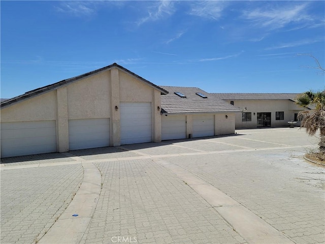 31801 Soapmine Rd, Barstow, CA 92311 - view of front facade with community garages, stucco siding, and a tile roof