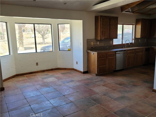 kitchen featuring vaulted ceiling with beams, dishwasher, and sink