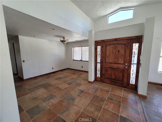 entryway featuring a textured ceiling and vaulted ceiling