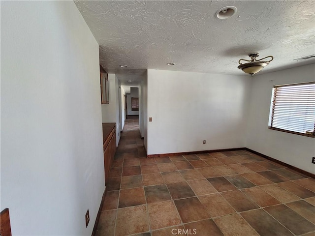 unfurnished room featuring ceiling fan and a textured ceiling