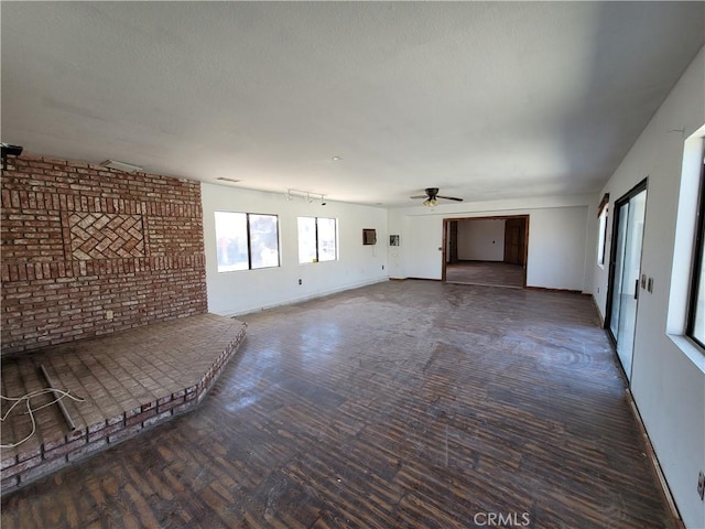 unfurnished living room with dark hardwood / wood-style floors and ceiling fan