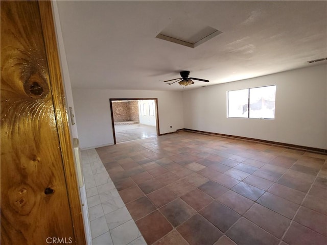 31801 Soapmine Rd, Barstow, CA 92311 - spare room featuring healthy amount of natural light, attic access, and dark tile patterned flooring