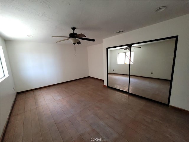 unfurnished bedroom featuring wood-type flooring, a closet, and ceiling fan