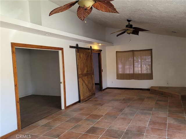 empty room with a textured ceiling, a barn door, vaulted ceiling, and dark wood-type flooring