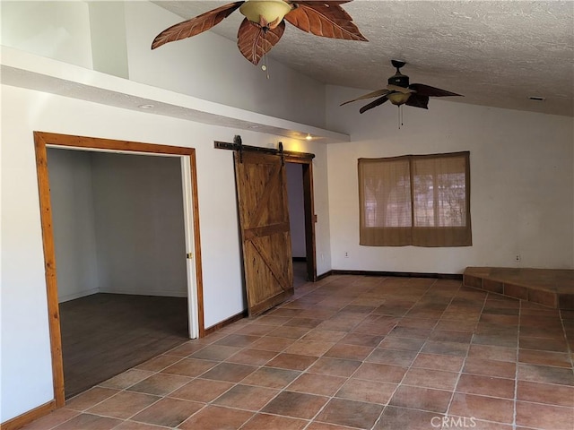 31801 Soapmine Rd, Barstow, CA 92311 - empty room featuring a barn door, ceiling fan, lofted ceiling, a textured ceiling, and tile patterned flooring