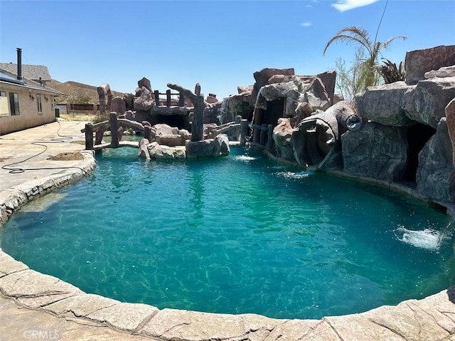 view of swimming pool with pool water feature