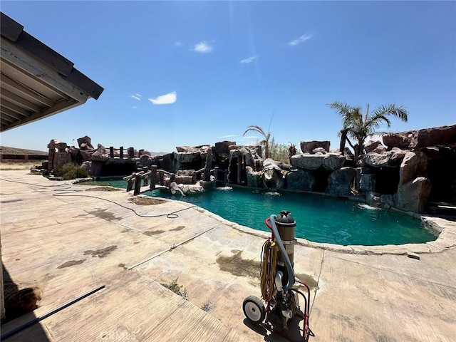 view of swimming pool with pool water feature and a patio