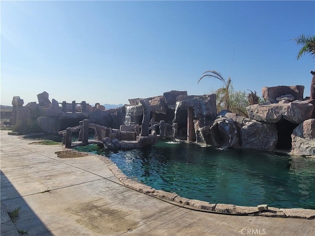 view of swimming pool with pool water feature and a water slide