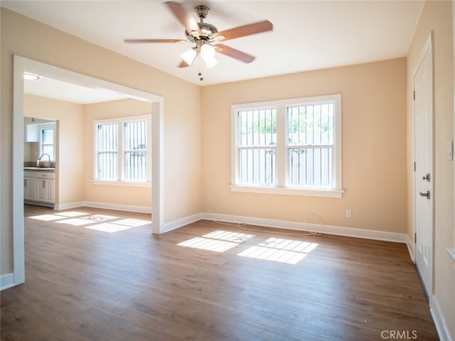 unfurnished room with dark hardwood / wood-style flooring and a healthy amount of sunlight