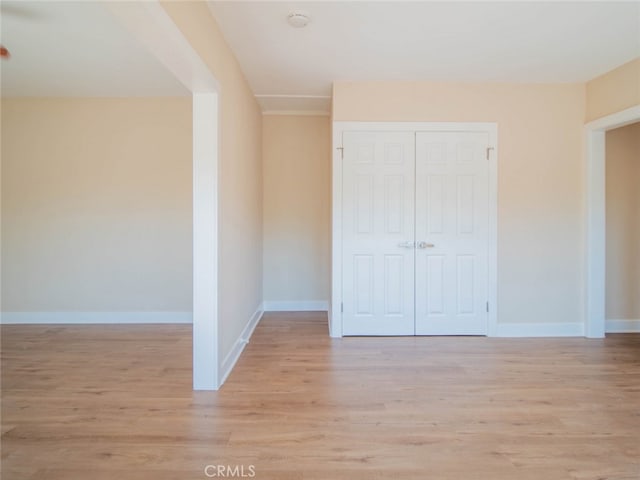 unfurnished bedroom with light hardwood / wood-style flooring and a closet