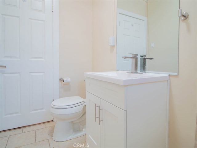 bathroom with tile patterned flooring, vanity, and toilet