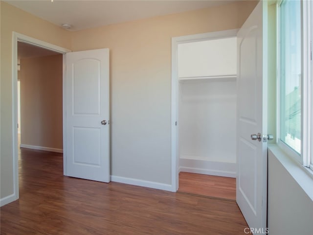 unfurnished bedroom featuring dark hardwood / wood-style flooring and a closet