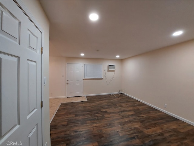 empty room featuring wood-type flooring and a wall mounted air conditioner