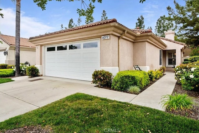 view of side of property with stucco siding, driveway, an attached garage, and a tile roof