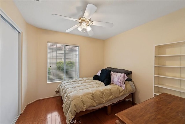 bedroom with wood finished floors, baseboards, and ceiling fan