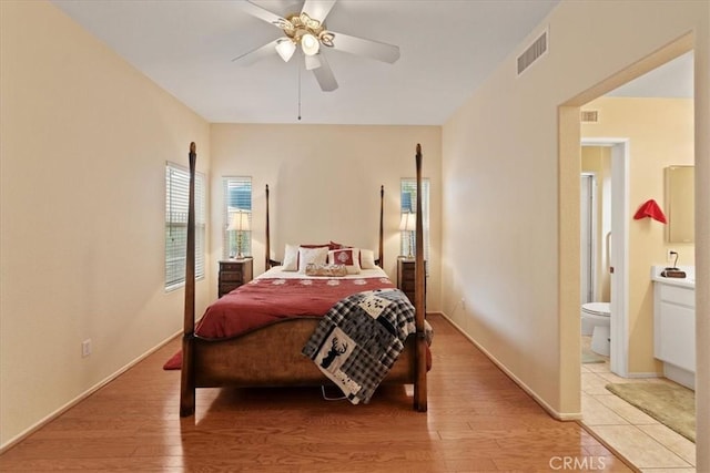 bedroom featuring ceiling fan, visible vents, baseboards, and light wood-style flooring