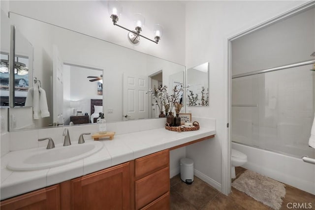 full bathroom with vanity, tile patterned flooring, ceiling fan, toilet, and enclosed tub / shower combo